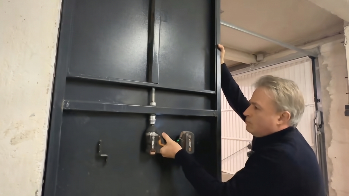 Technicien installant une porte anti-intrusion temporaire sans percer le bâti existant.